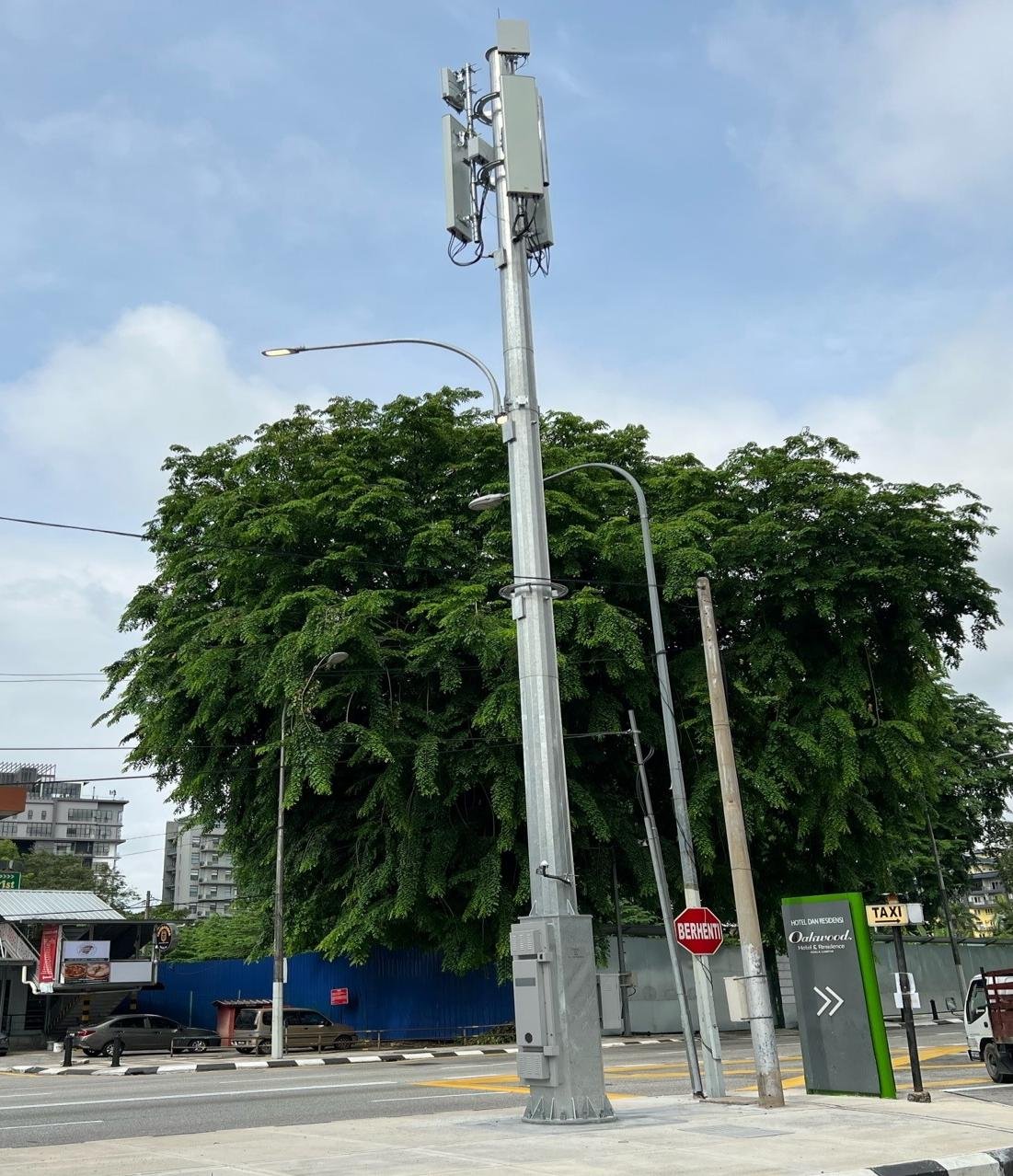 Demanlink 5G smart pole installed on a Sarawak street, carrying 5G and street-lighting on one slim structure